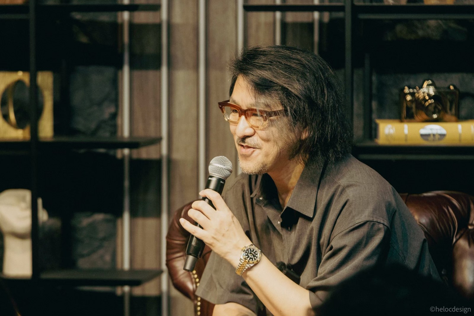 Tadahiro Koto speaking into a microphone at his talk event in Akasaka, Tokyo
